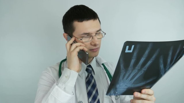 male doctor looking at x-ray talking and smiling