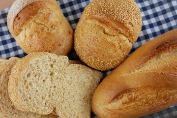 Various breads and toasts top view on blue plaid fabric