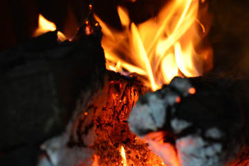 Fire in the fireplace, tongues of flame from a burning log on fire