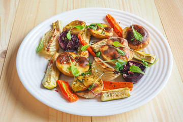 Baked vegetables in large pieces on a plate. Vegetarian diet. Close up. Vegetable garnish grill.
