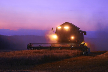 Combine harvester working on a wheat crop at night
