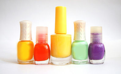 jars with nail varnish of different color and the size on a white background