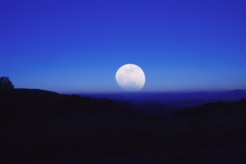 Naklejka na ściany i meble Full Moon from the mountain silhouettes landscape. 
