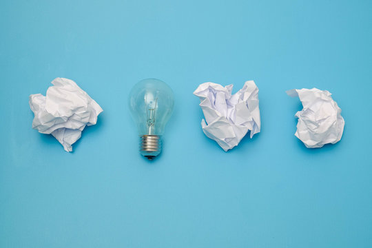 great concept with crumpled office paper and light bulb on a blue background