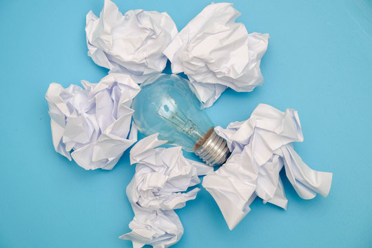 great concept with crumpled office paper and light bulb on a blue background
