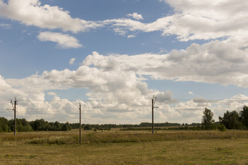 Huge white clouds in the cold autumn sky over green fields, trees, forests, streams. sunne day....