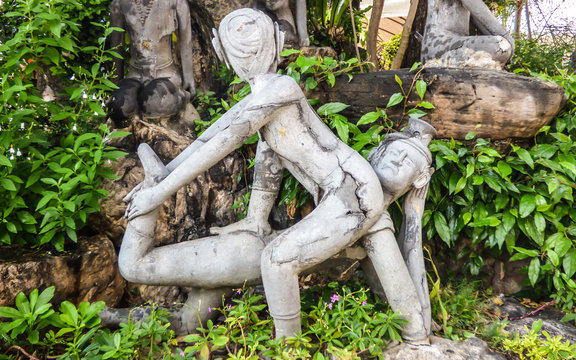 Old stone statue depicting a Nuad Boran (Thai massage) move at famous Wat Pho (Buddhist Temple) in Bangkok, Thailand