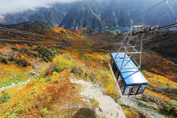 Aerial scenery of a scenic cable car flying over the beautiful autumn valley in the Tateyama Kurobe...