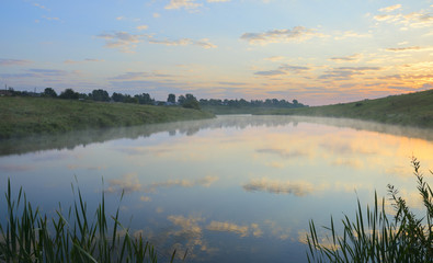 Foggy summer landscape.Rising sun.Serene morning.Calm.River Krasivaya Mecha in Tula region,Russia. 