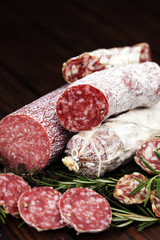 thinly sliced salami on a wooden texture on the background.