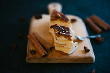 Cake on a wooden tray on a black matte background
