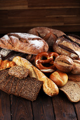 Different kinds of bread and bread rolls on board from above. Kitchen or bakery poster design