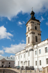 Ancient monastery of Discalced Carmelites, cathedral and fortress wall on background of blue cloudy sky. Berdychiv, Ukraine. Tourist attraction. Place of visit by Pope John Paul II