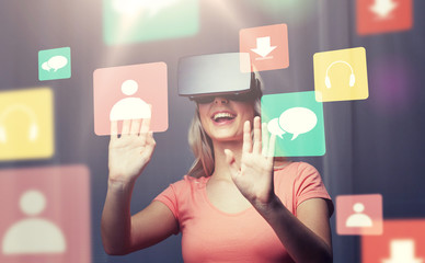 technology, virtual reality, entertainment and people concept - happy young woman with virtual reality headset or 3d glasses playing game at home looking at menu icons projection