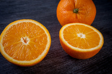 useful vitaminized food with vitamin c, whole and cut oranges are on the table