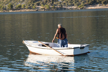 Fototapeta na wymiar The fisherman on the old boat is hunting fish