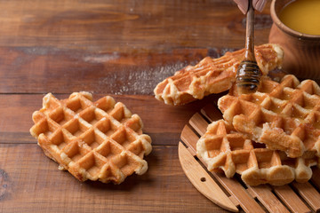 Honey pouring on a fresh waffles. Breakfast with waffles