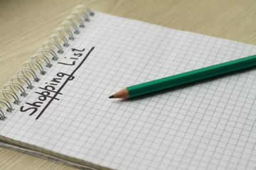 Shopping list in notebook, green pencil, write.