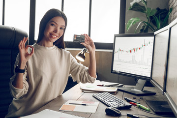 Happiness manager holding bank card and showing ok sign.