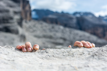 Closeup of fingers gripping a rock.