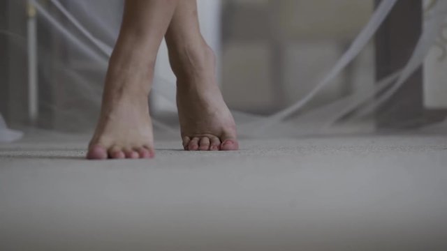 The legs of a woman are walking on the floor