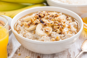 healthy breakfast - oatmeal with banana, honey and walnuts in a bowl