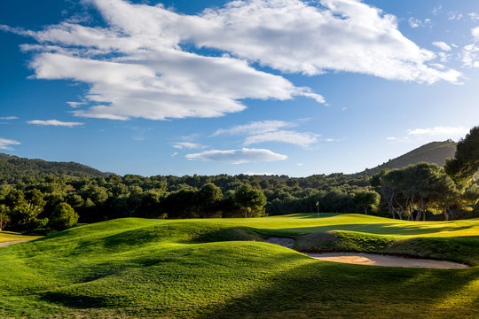 Golf course on sunset with green grass, blue sky and clouds. Photo taken in Spain at the La Manga Club. 