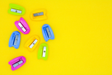 colorful of plastic pencil sharpener on yellow background - background
