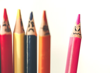 Selective focus on pink pencil with angry face on white background 