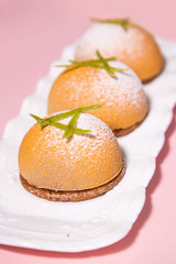 Mini mousse cakes covered with yellow chocolate velour