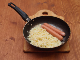 warmed vermicelli with sausages on an old frying pan