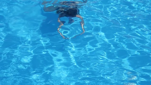 Girl swimmer floating under Pure blue water in Swimming-pool in Slow motion