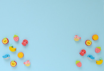 Eraser in the form of little things: fruits, fish. Background for a children's theme. Children's sale with Copyspace.  Little boy. 