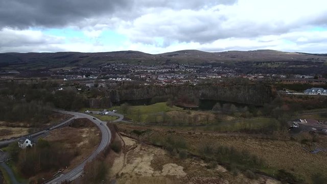 Aerial footage looking over the water filled Auchinstarry Quarry at Kilsyth, Scotland, UK.  Popular location for rock climbing. 