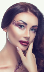 Fototapeta premium Portrait of a beautiful young brunette girl, which was applied make-up in a beauty salon.