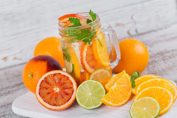Citrus fruit and herbs water for detox or dieting in glass bottles. Limes and oranges