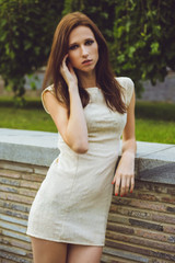 Young beautiful girl with brown-haired woman in dress walking walks in park in nature and posing. Fashion photo