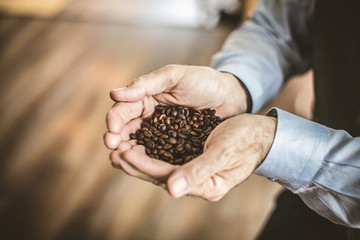 Close up image senior man with whole grain coffee in his hand.