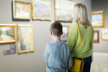 Ordinary mother and son exploring paintings