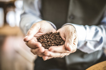 Close up image senior man with whole grain coffee in his hand.