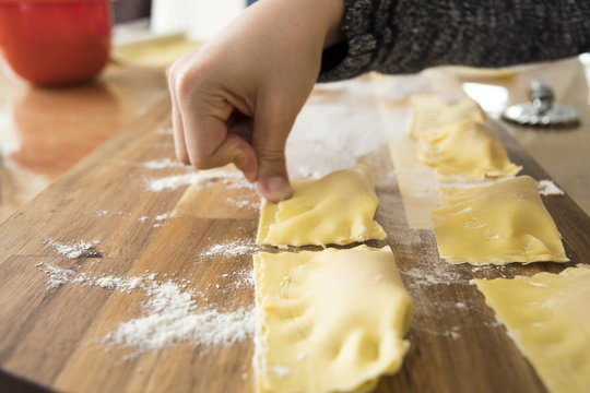 Raw dough for handmade italian ravioli with child hand