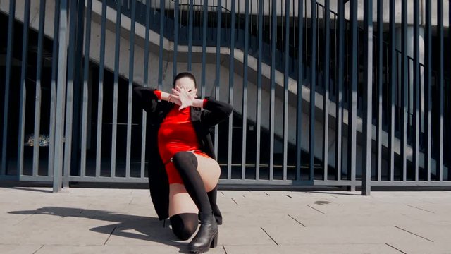 Sexy female dancer in Vogue and Waacking dance style dancing in the city with urban background.