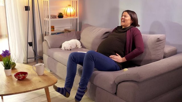 Beautiful pregnant woman feeling strong contractions asking for help calling husband