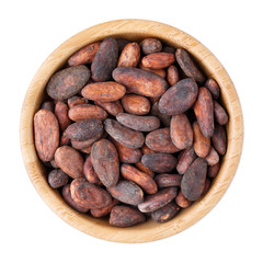 Cocoa beans in a wooden bowl isolated on white. Top view.