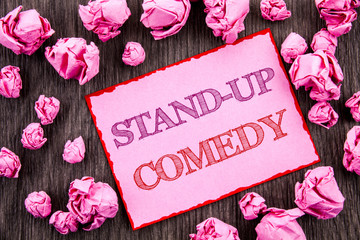 Handwriting text showing Stand Up Comedy. Business photo showcasing Entertainment Club Fun Show Comedian Night written on Pink Sticky Note Paper Folded Paper on wooden background