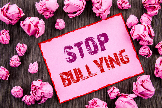 Handwriting text showing Stop Bullying. Business photo showcasing Awareness Problem About Violence Abuse Bully Problem written on Pink Sticky Note Paper Folded Paper on wooden background