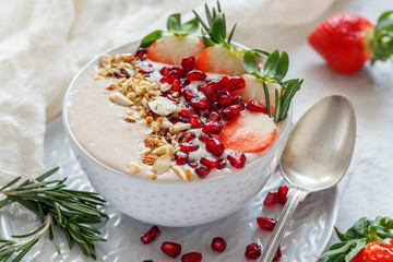 Healthy smoothie bowl of strawberries, pomegranate and almonds.