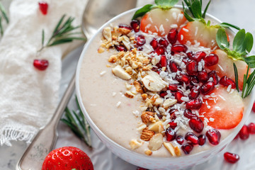 Smoothie bowl of strawberries, pomegranate and almonds.