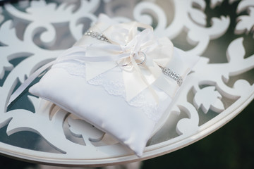Wedding rings on the white pillow on the ceremony table