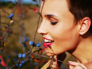 Portrait of a young beautiful girl near a berry turn.